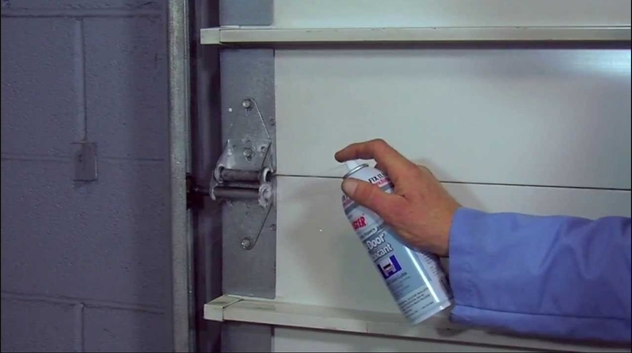 Lubricating garage door hinges to fix noisy garage door.