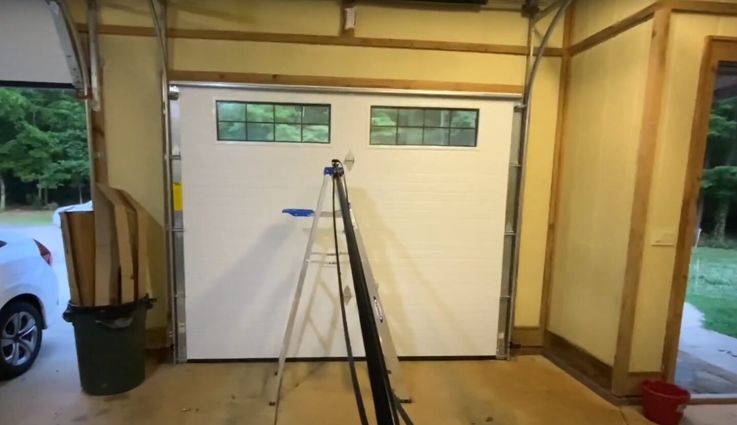 A skilled technician from Powell Garage Door Repair working on a garage door spring replacement, ensuring safety and precision
